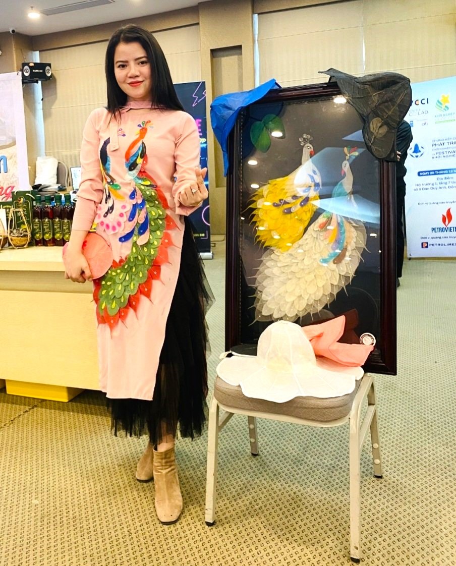 Cô giáo Nguyễn Như Sinh khoác trên mình trang phục làm từ lá cây cùng bức tranh và các sản phẩm thời trang handmade khi tham gia vòng thi chung kết Chương trình Phát triển dự án khởi nghiệp quốc gia năm 2022 tại Hà Nội vào hôm qua 20/12. Ảnh: Nhân vật cung cấp